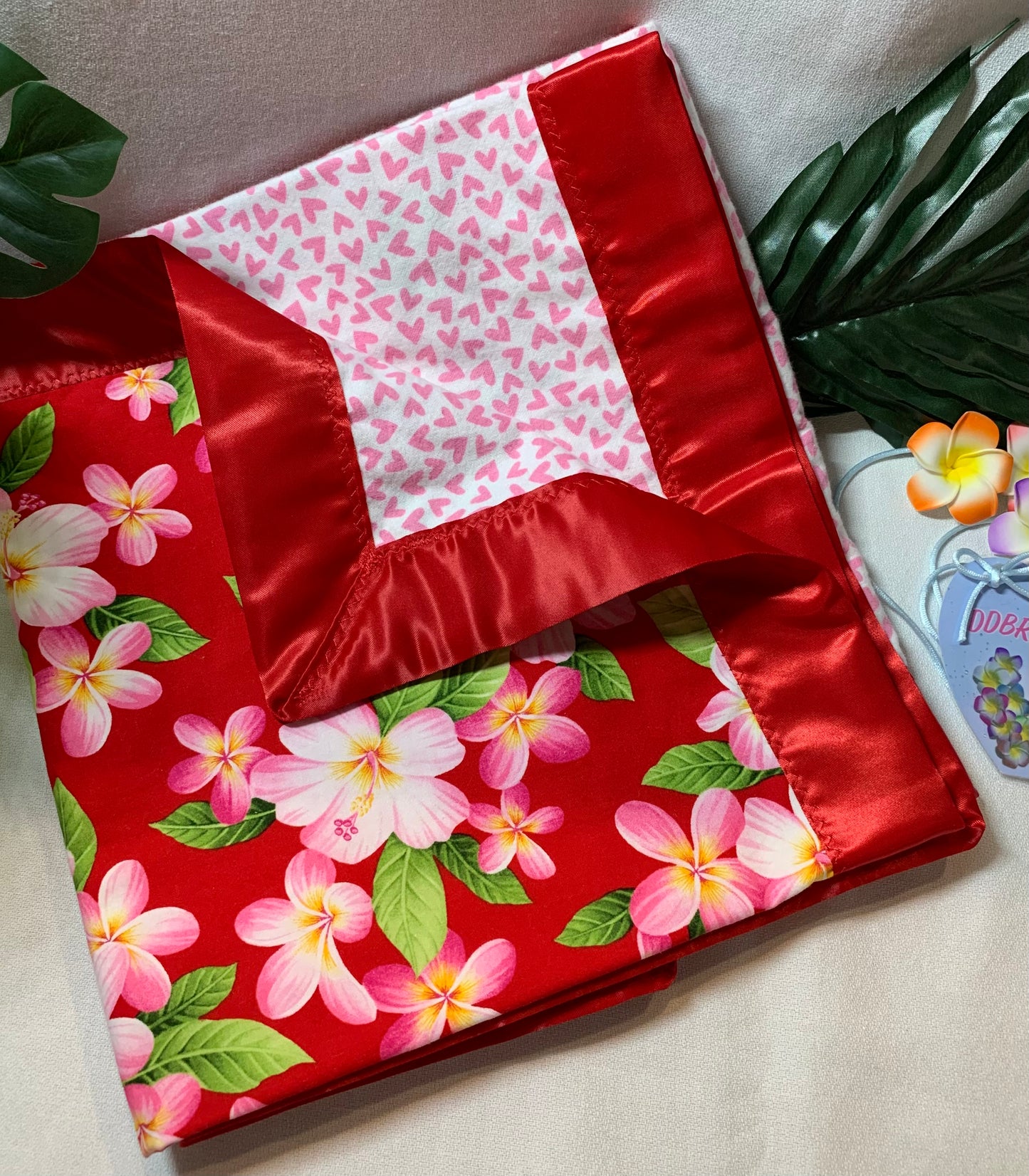 Plumeria print 100% cotton baby blanket with satin trim.