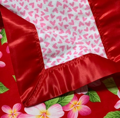 Plumeria print 100% cotton baby blanket with satin trim.